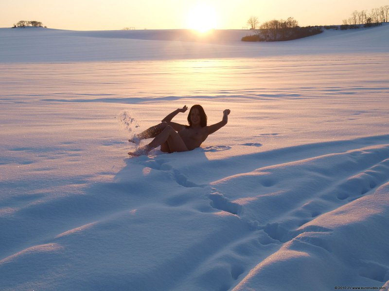 Голая девушка позирует на снегу